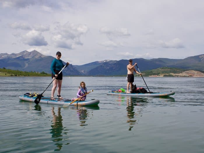 Paddleboarders gliding across Lake Dillon on a calm morning